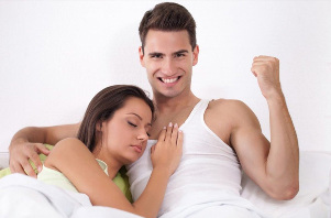 Starker Mann im Bett mit einem Mädchen