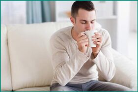 Ein Mann trinkt Tee mit Minze, um erektile Dysfunktion zu heilen. 